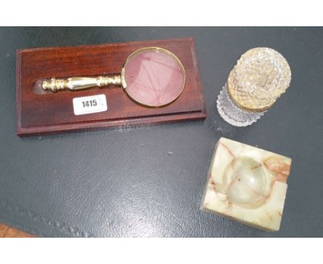 AN EARLY 20TH CENTURY BRASS DESK STAND highly embossed, together with a brass topped table lighter, brass magnifying glass on