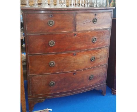 A 19TH CENTURY MAHOGANY BOW FRONT CHEST OF DRAWERS with two short over three long with brass ring handles standing on bracket