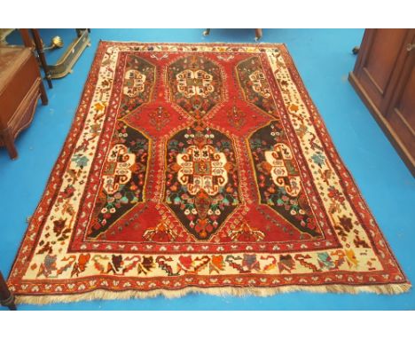 AN IRANIAN HAMADAN RED GROUND CARPET with wide cream patterned bordeR and all over decoration. 8'1" x 5'3".