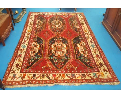 AN IRANIAN HAMADAN RED GROUND CARPET with wide cream patterned bordeR and all over decoration. 8'1" x 5'3".