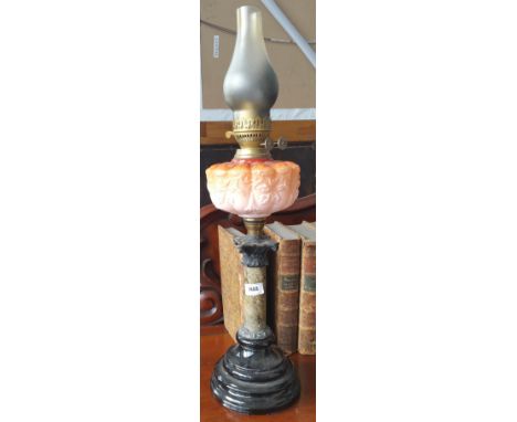 AN EARLY 20TH CENTURY OIL LAMP with marble column and moulded orange glass reservoir.
