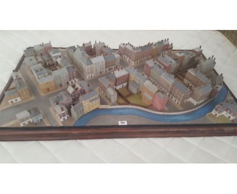 A MINIATURE MODEL OF A TOWN with houses, streets and a river.