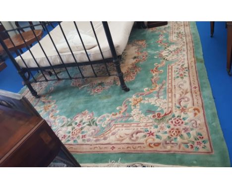 A LARGE CHINESE CARPET ON GREEN GROUND and all over decoration. 12ft x 9ft.