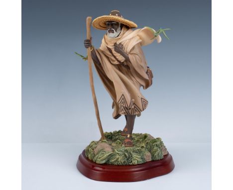 This is an intricate charming figure of a man fashioned in African robes, carrying a walking stick. He is surrounded by beaut
