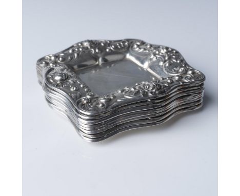 A set of eight Gorham sterling silver trinket dishes, each featuring a square design with scalloped edges and intricate flora