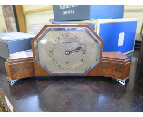 A Elliott walnut cased table timepiece clock, in the Art Deco style, retailed by Bracher &amp; Sydenham, with chrome feet, 28