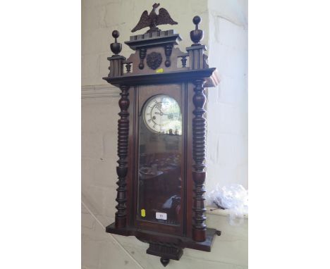 An early 20th century Vienna type wall clock, by Gustav Becker, the turned surmount with eagle and lion's head over a white d