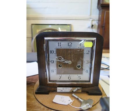 A 19th century French alabaster mantel clock with painted blue highlights, surmounted by cupid, the twin train movement strik