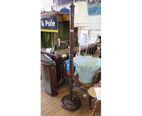 An Oriental style carved wood standard lamp, with spiralling dragon decoration on a turned circular base with bracket feet, 1
