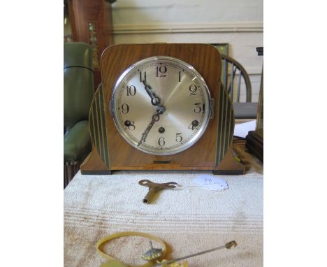 An inlaid walnut Art Deco style mantel clock, with silvered dial and three train movement striking on gongs, 21 cm high 