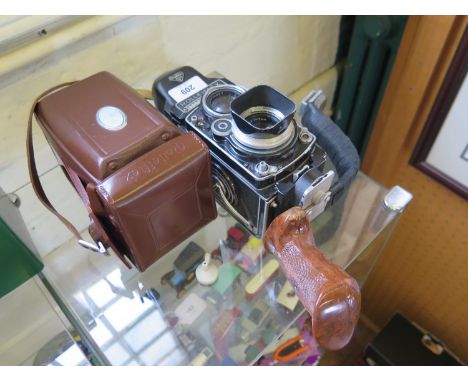 A Rolleiflex TLR DBP DBGM camera 3.5f number 2263362, with additional prism viewfinder attachment, and custom made hand grip,