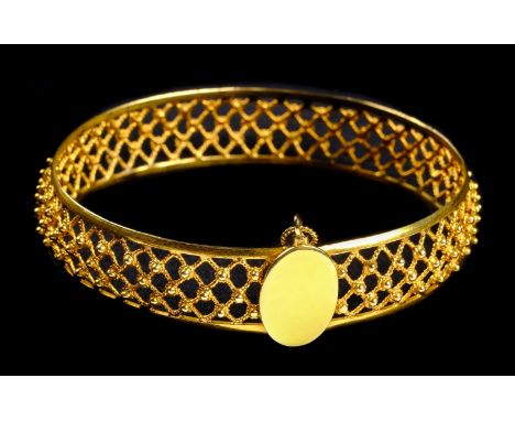 Bangle. A Continental 18k gold ladies bangle, with pierced lattice work decoration, the oval clasp stamped '18K', 7cm diamete