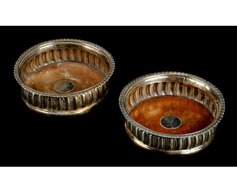Coasters. A pair of Georgian silver wine bottle coasters by Thomas Newby, London 1816, gadrooned sides and wooden base inset 