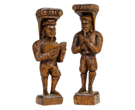 Oak figures. A pair of carved oak male figures playing musical instruments, late 19th/early 20th century, one playing a woodw