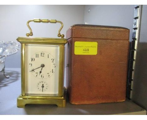 An early 20th century brass cased alarm carriage clock with travel case 