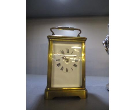 A late 19th/early 20th century brass cased carriage clock having a white enamelled dial and Roman numeral, 5 3/4"h including 