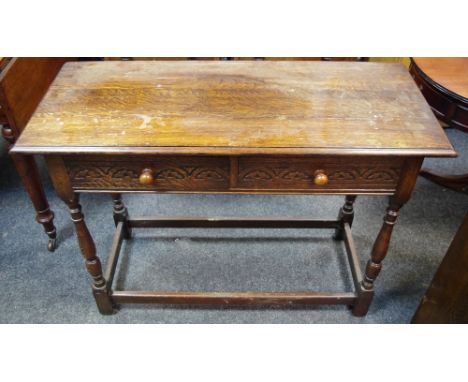 An oak hall table, moulded top, two short blind fretworked drawers to frieze, button handles, turned and blocked supports.