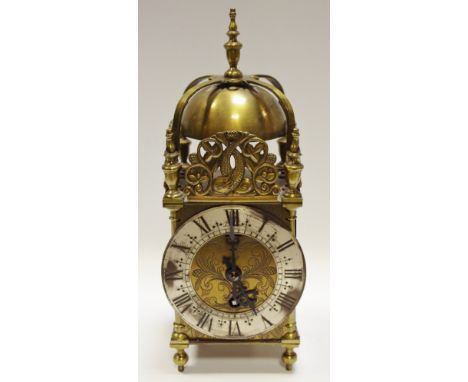 An Elliott lantern clock with Roman numerals and silvered chapter ring, surmounted by stylised dolphin panel, 30cm tall 