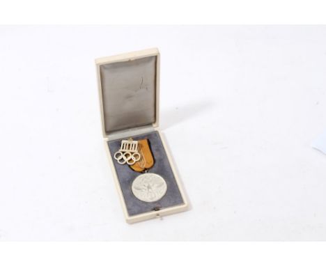 Nazi 1936 Olympic Games commemorative medal in box of issue, together with a white enamel and gilt badge (2)