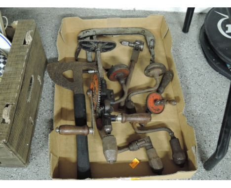 A box of vintage hand tools including drills, braces and fireman axe etc