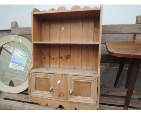 A pine wall shelf with double cupboard under