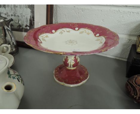 A ceramic tazza/ cake stand in red and gilt 