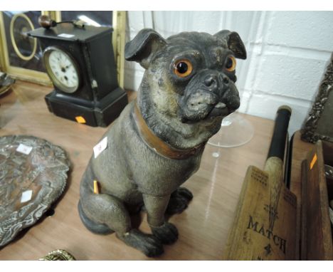 An early 20th century ceramic pug dog figure painted with glassy eyes