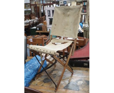 A WORLD WAR II FOLDING WOODEN AND METAL CHAIR with canvas seat and back, stamped with government arrow and '1944'