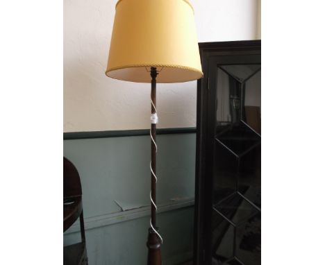 Victorian mahogany standard lamp with gold parchment shade on carved circular base, three splayed feet