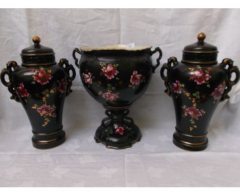 Pair of black painted multi-floral coloured urn shaped handled mantelpiece vases together with a central pedestal vase on cir