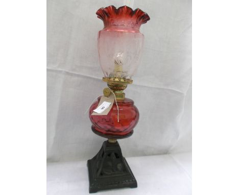 Metal based table lamp with ruby glass bowl and decorative floral patterned cranberry glass shade and chimney