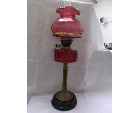 Fine circular pot based lamp with brass corinthian column, the ruby glass bowl and an ornate cranberry glass shade and chimne