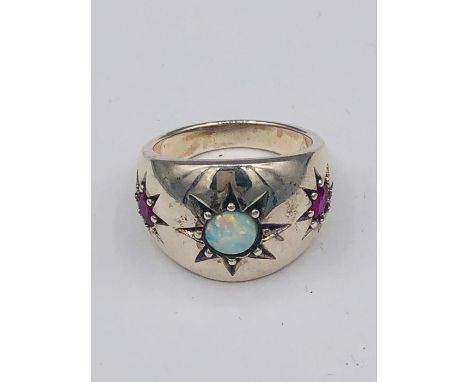 A silver three stone ring of central opal flanked by Rubilites