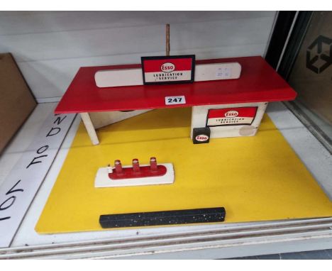 An Esso toy garage mounted on a yelloow board
