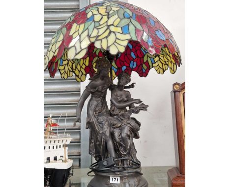 A pair of bronzed classical ladies as a table lamp with a leaded glass shade