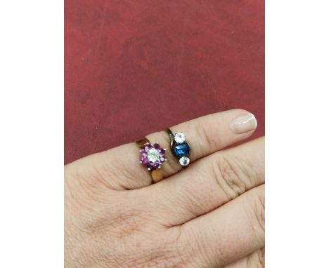 A 9ct hallmarked gold ruby and diamond cluster ring, and a three stone unhallmarked ring assessed as 18ct gols mount and 9ct 