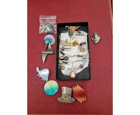 A collection of vintage stick pins and celloid brooches. 