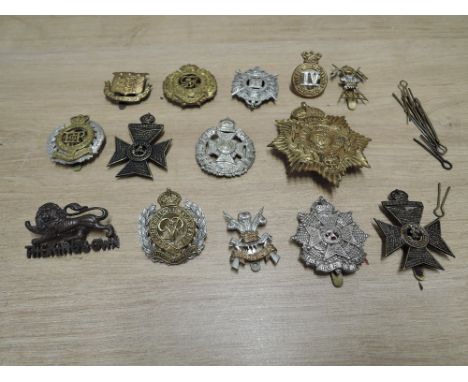 A collection of 14 Military Cap Badges including Kings Own, Border Regiment, Gibraltar, Kings Royal Rifle Corps, Royal Engine