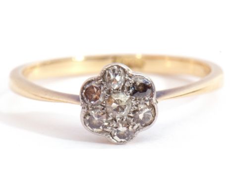 Small diamond cluster ring featuring seven small diamonds in a flowerhead design with millegrain edging, stamped 18ct, size J