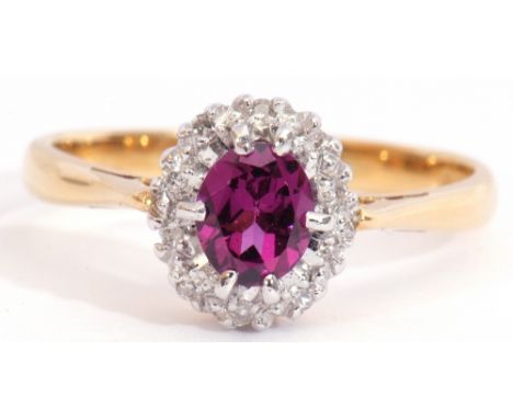 18ct gold amethyst and diamond cluster ring, the oval faceted amethyst multi-claw set and raised above a surround of small si