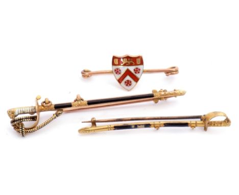 Mixed Lot: 9ct stamped sword brooch decorated with white and black enamel detail, 6cm long, 9ct gold enamelled shield brooch,