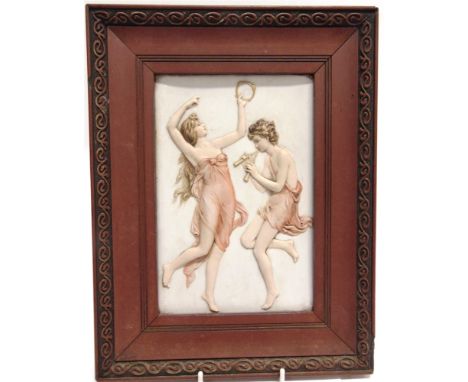 A FRAMED CERAMIC PANEL  relief decorated with dancing figures, 26cm x 34cm overall