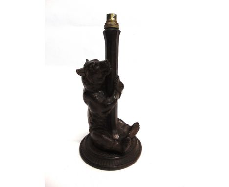 A BLACK FOREST FIGURAL TABLE LAMP  modelled as a seated bear on circular base, 36.5cm high overall