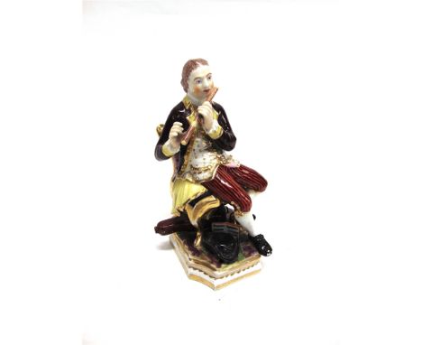 AN EARLY 19TH CENTUY DERBY FIGURE  of a seated gentleman playing a flute, polychrome enamelled with gilt highlights, incised 