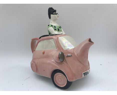 A glazed pottery teapot in the form of a bubble car.