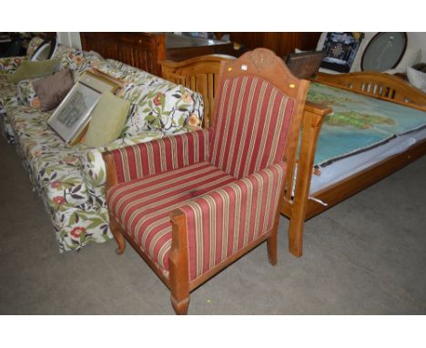 An early 20th Century stripe upholstered deep seated arm chair 