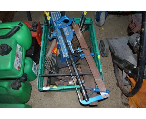 A plastic crate of various hand tools and a mitre saw