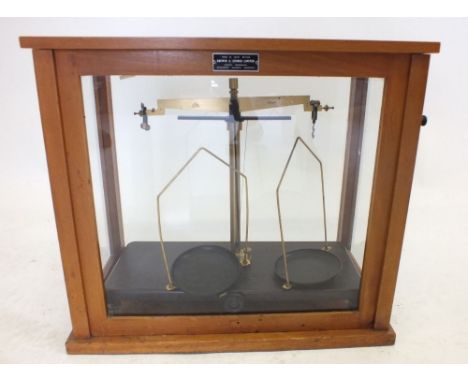 A set of brass balance scales in glazed cabinet 