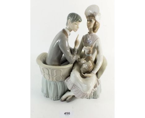 A Lladro figurine of a man and woman sitting holding a dog, 26.5cm high 