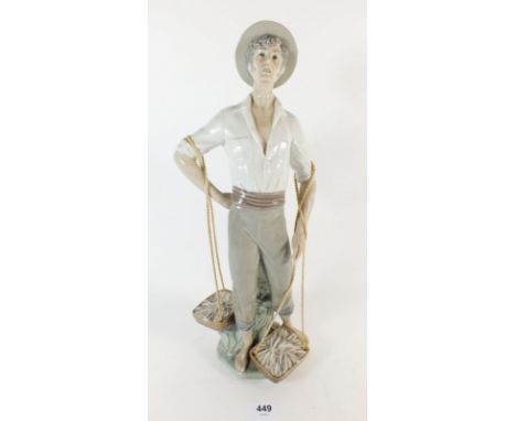 A Lladro figure of man holding baskets, 37.5cm high 
